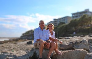 couple sitting on rocks at the beach