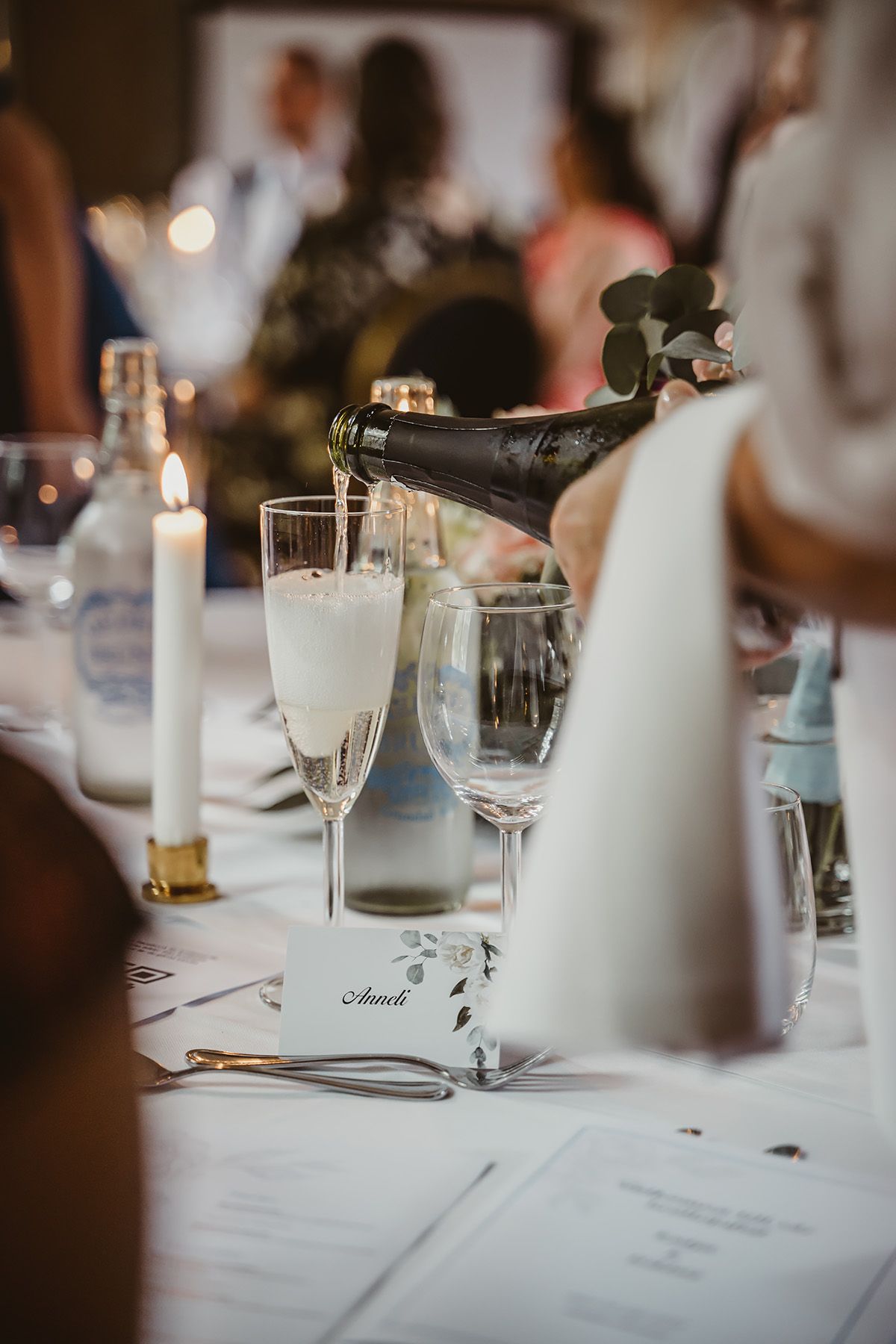 Bröllopsmiddag i Brunnssalongen på Medevi Brunn utanför Motala – champagne hälls upp. Bröllopsfotograf Josefin Landhagen i Östergötland.