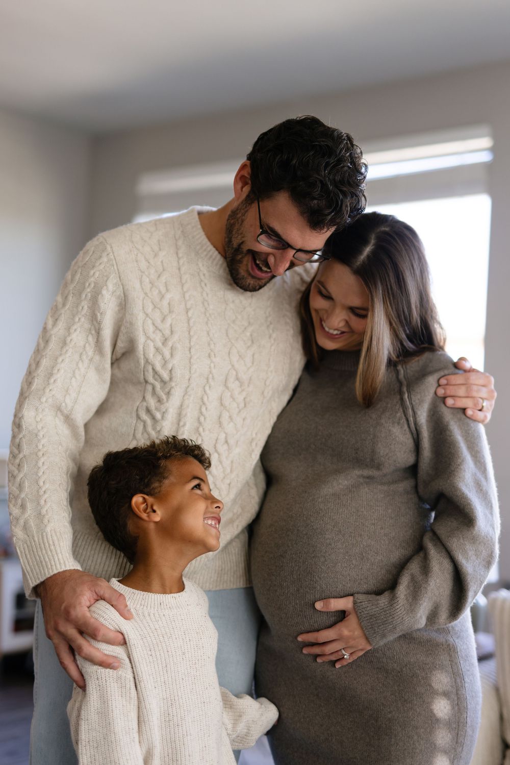 A heartwarming sequence showing a tender moment between parent and child wearing cozy sweaters in a bright room.