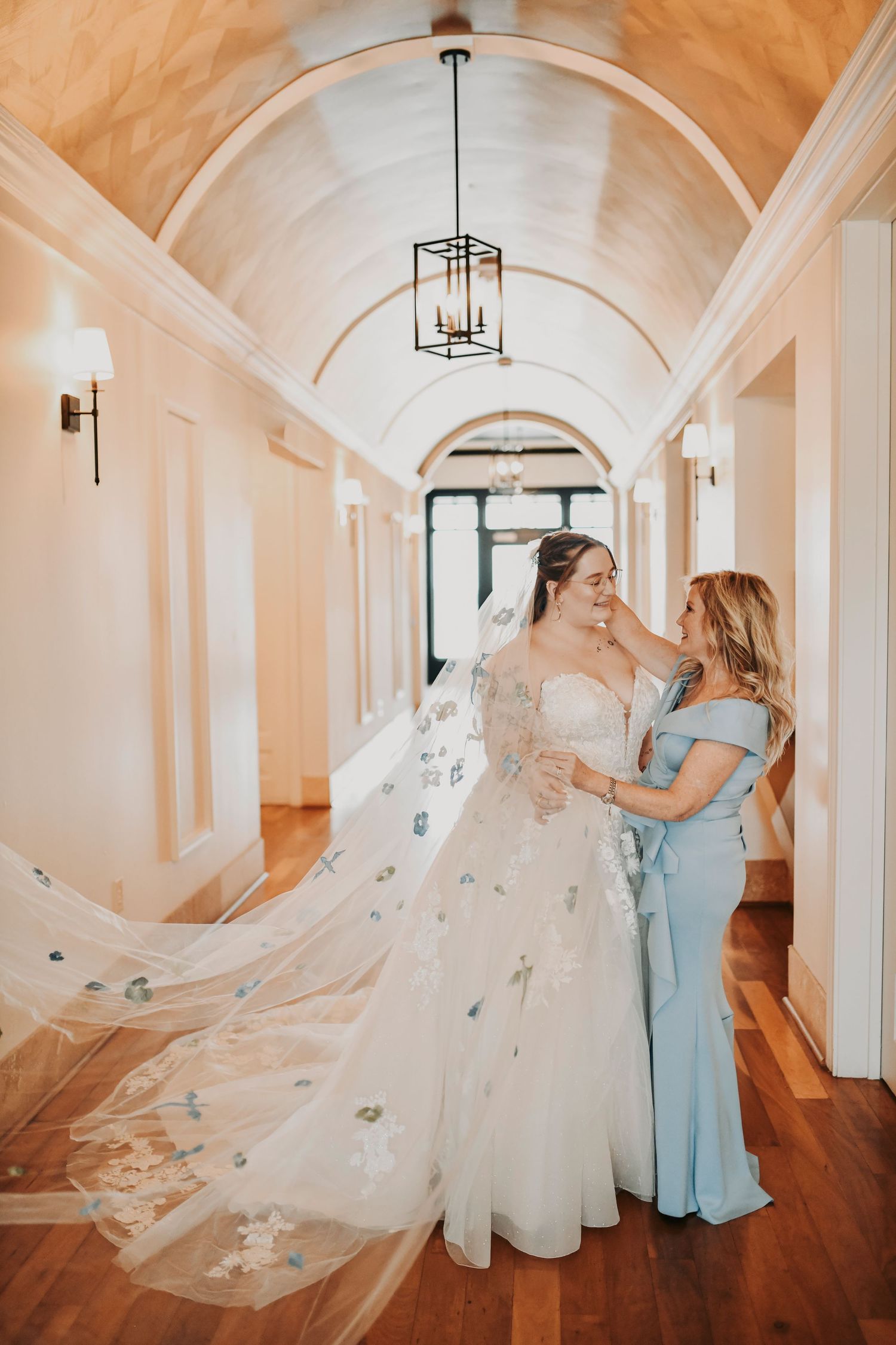 Bride’s mother placing a cathedral veil on her daughter during an intimate getting ready moment at The Dalmore Event Venue in Fort Worth