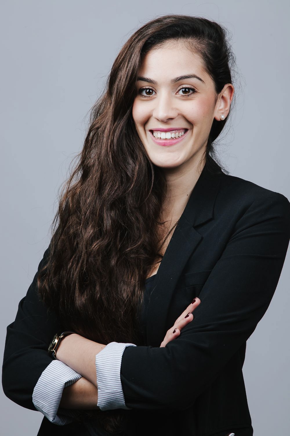 Professional headshot series showing a person in a black blazer and white top posing with different expressions against gray backdrop.
