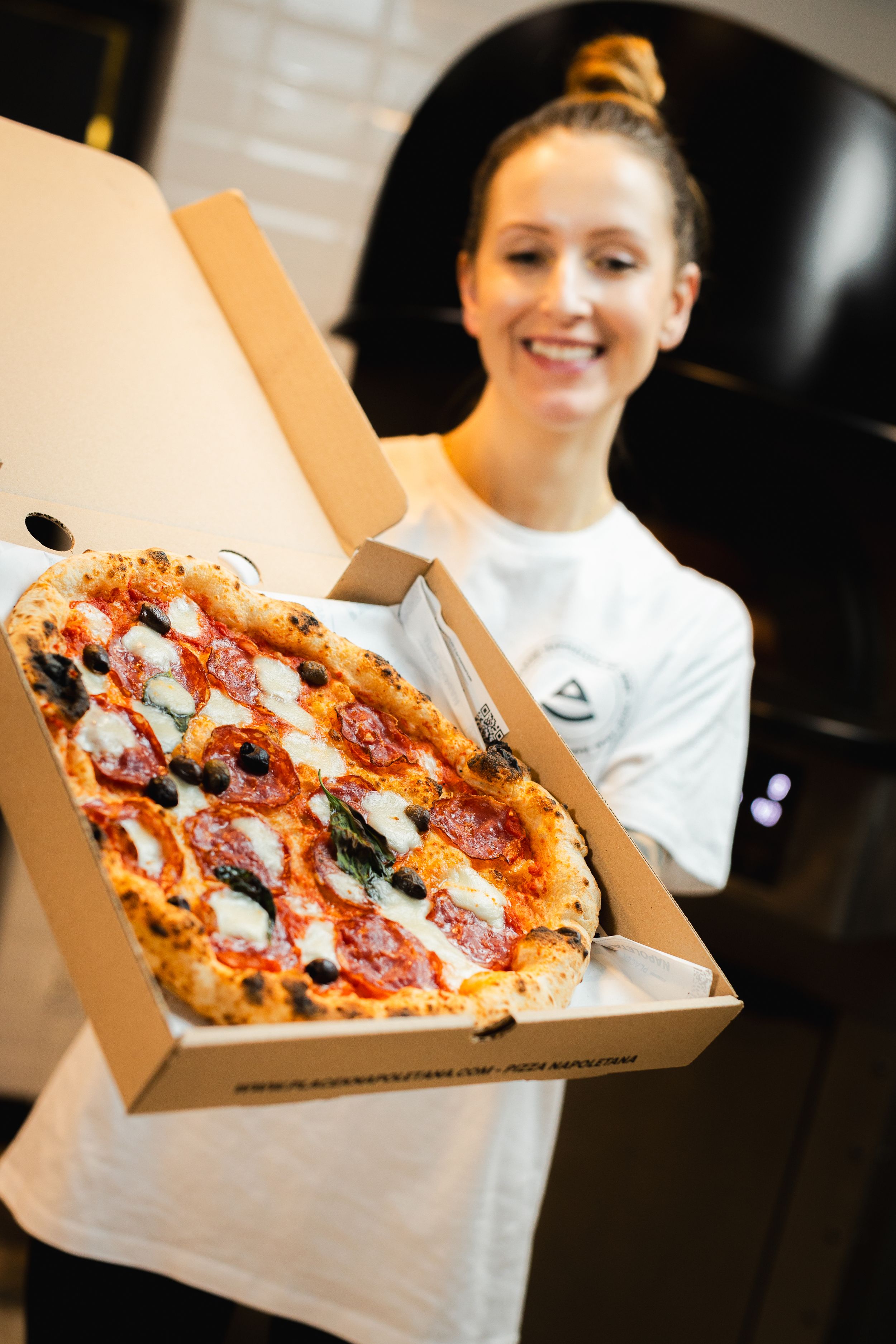 Świeża pizza neapolitańska z bazylią i mozzarellą w białym pudełku na wynos. Fotografia biznesowa Lublin.