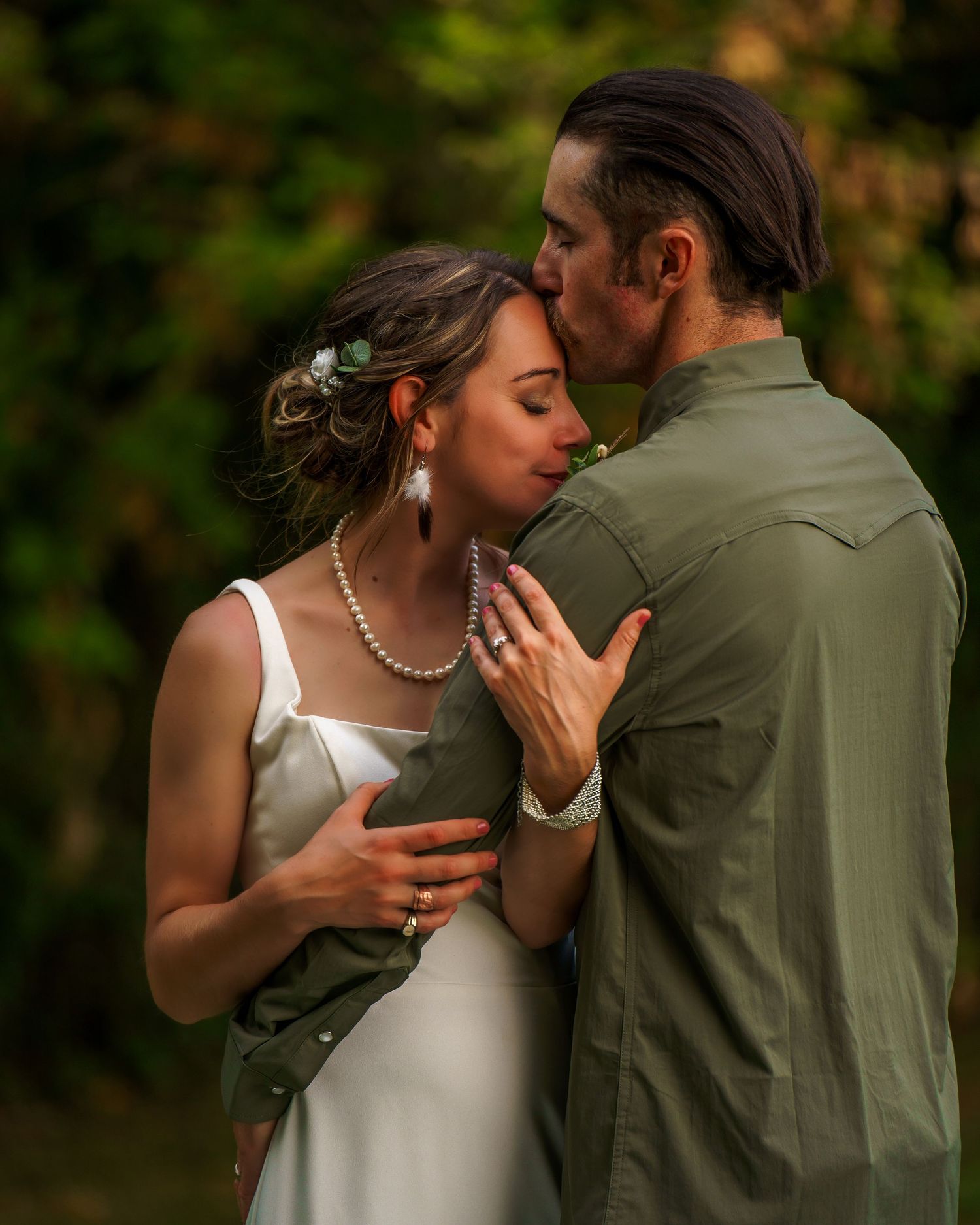 A romantic wedding portrait outdoors with a flowing white dress catching the breeze against an autumn landscape backdrop.