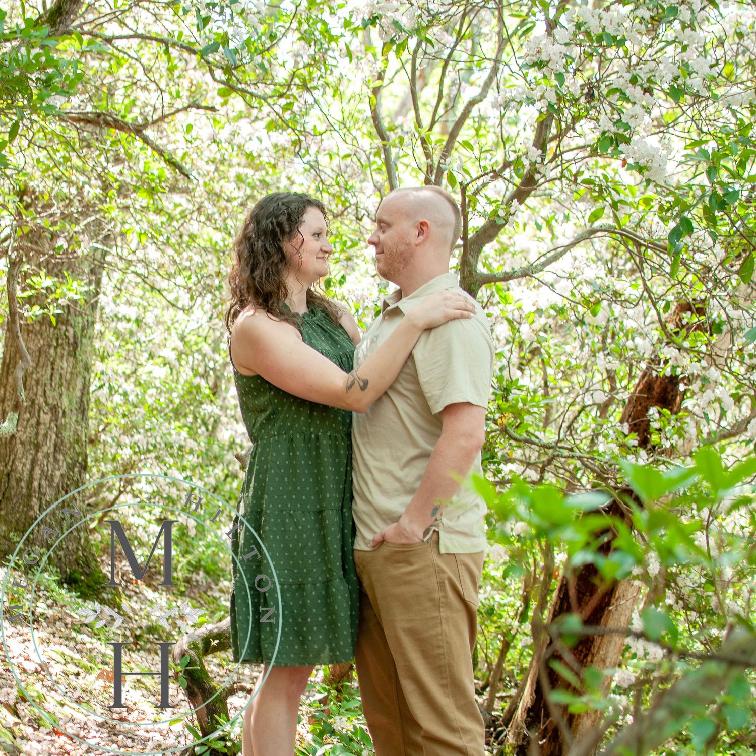 Couple embraces tenderly under blooming spring trees in sequence of romantic outdoor photographs.