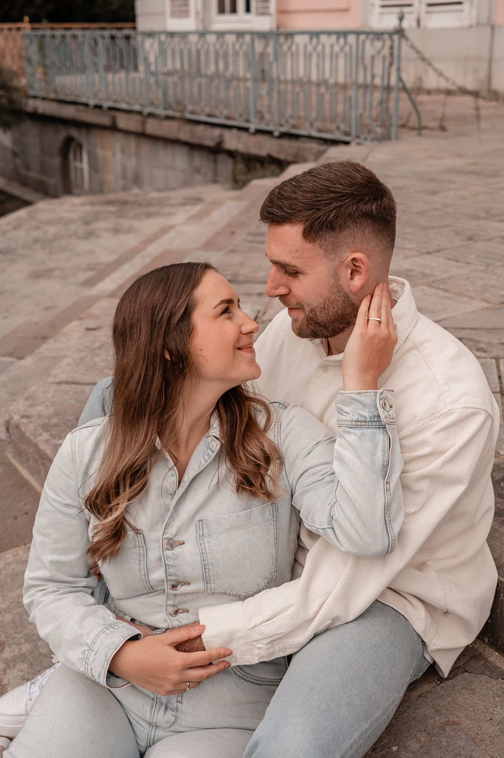 A couple in light denim and white outfits share intimate moments in a series of romantic outdoor photos.