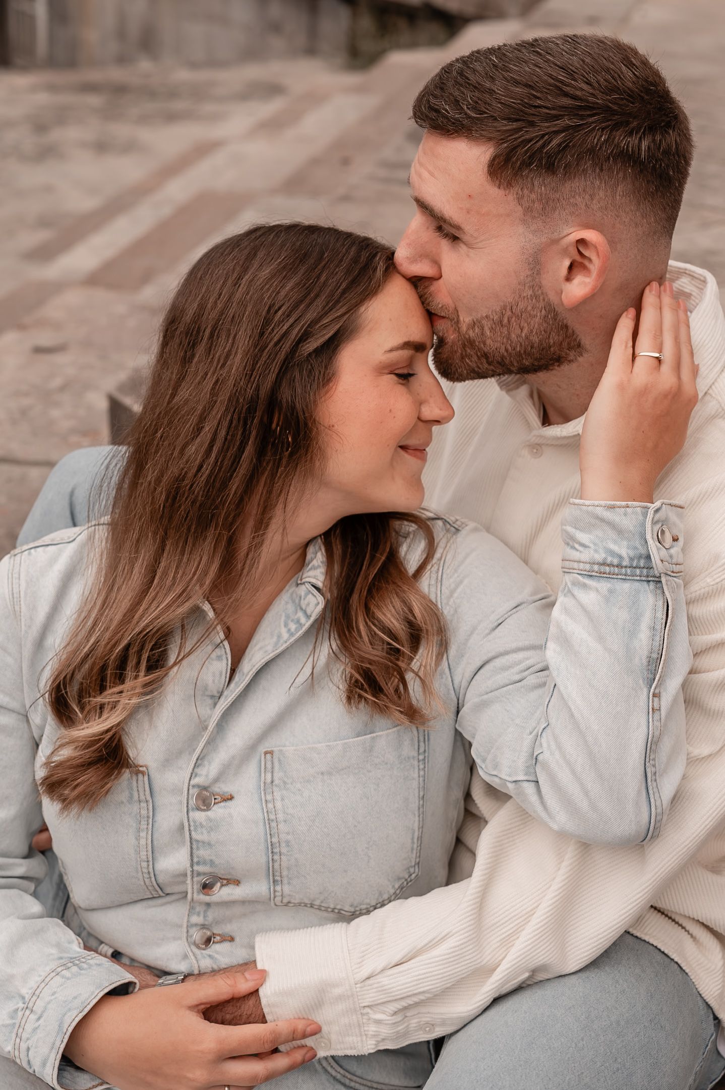 A romantic couple in denim and white clothing share intimate moments in a series of tender poses.