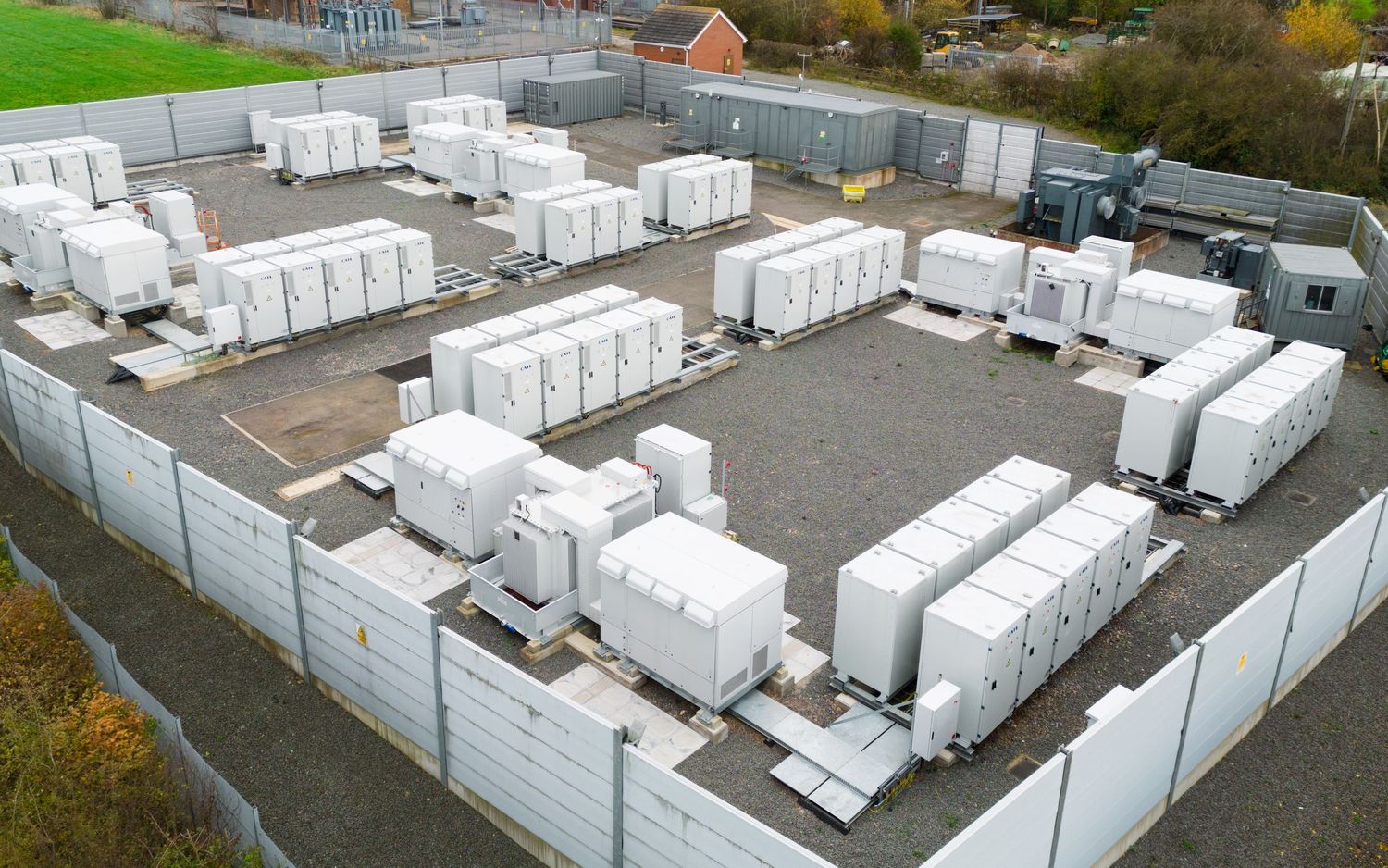 Aerial view of white modular container homes arranged in rows at temporary housing facility.