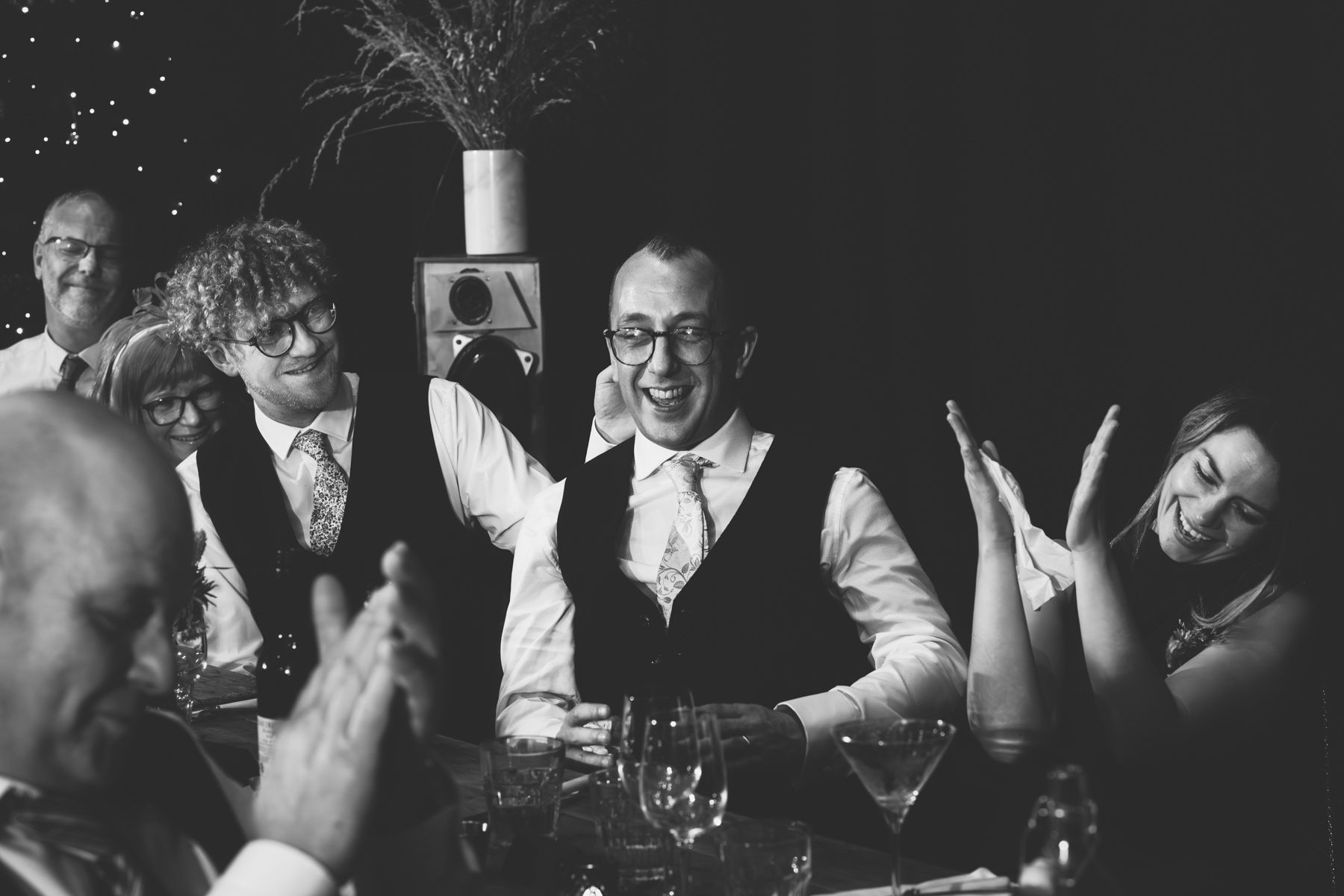 A group of people enjoying conversation and wine at a dimly lit restaurant table.