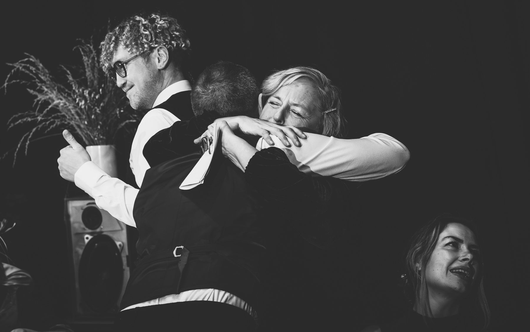 A black and white candid photograph showing energetic performers on stage during what appears to be a theatrical moment.