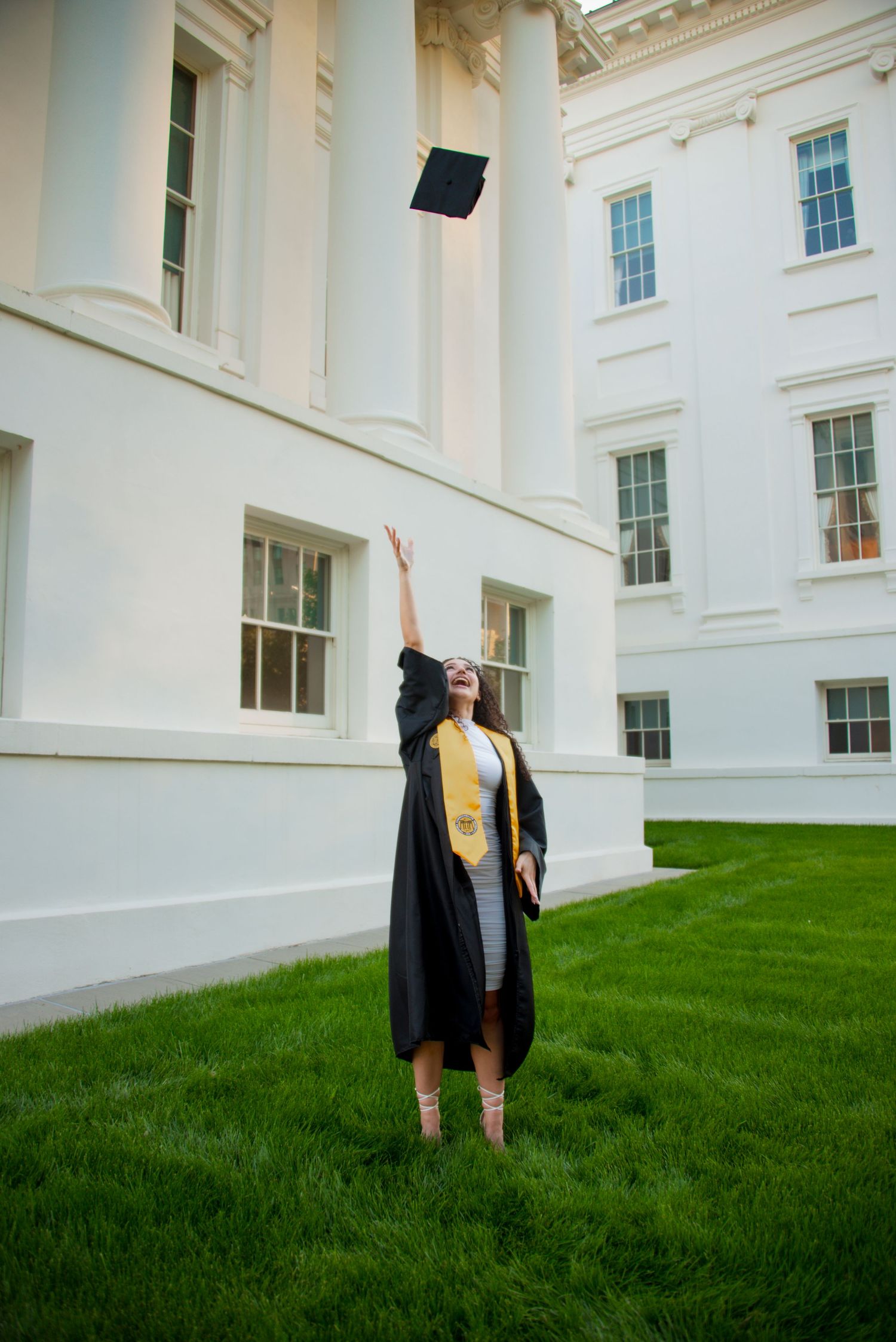 Graduate throwing cap in Richmond, Virginia photography shoot