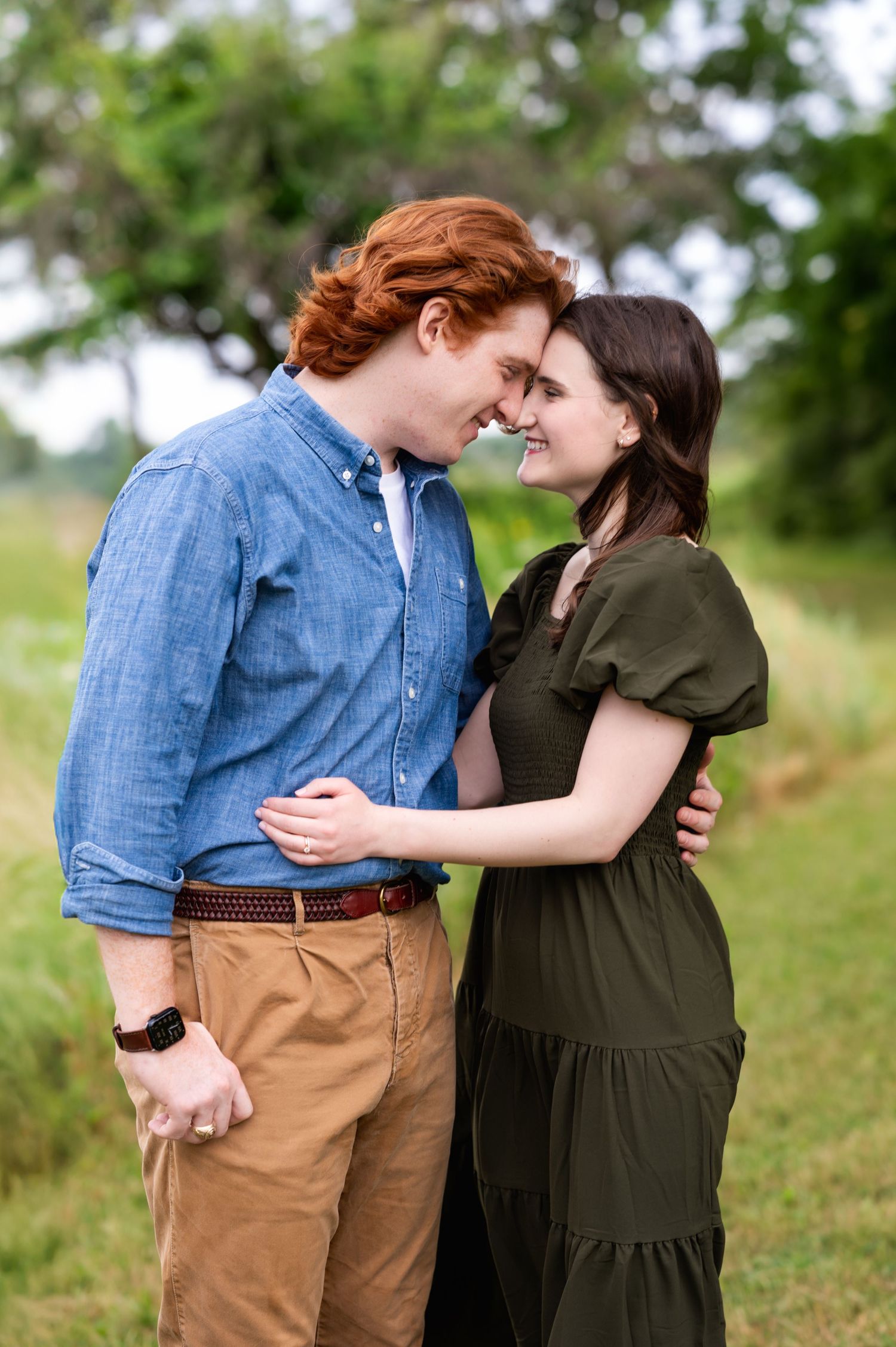 couple facing each other foreheads touching & smiling during family photo session in dallas by white rock lake by mesquite photographer