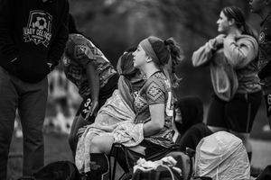 Black and white photo of people drinking or chugging from bottles in a festive outdoor setting.
