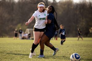 Soccer players competing for the ball during an intense match on a grass field.