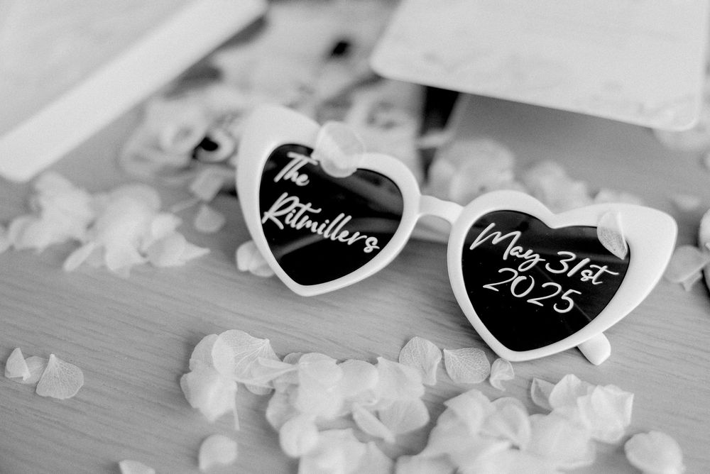 Small decorative black heart shapes with text arranged on a light surface with bokeh effects in the background.