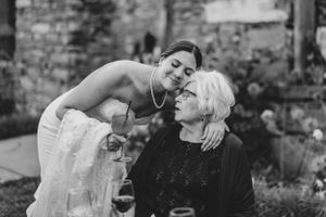 A touching black and white photo shows a sweet moment between a person in a white dress and an elderly person sharing intimate space.