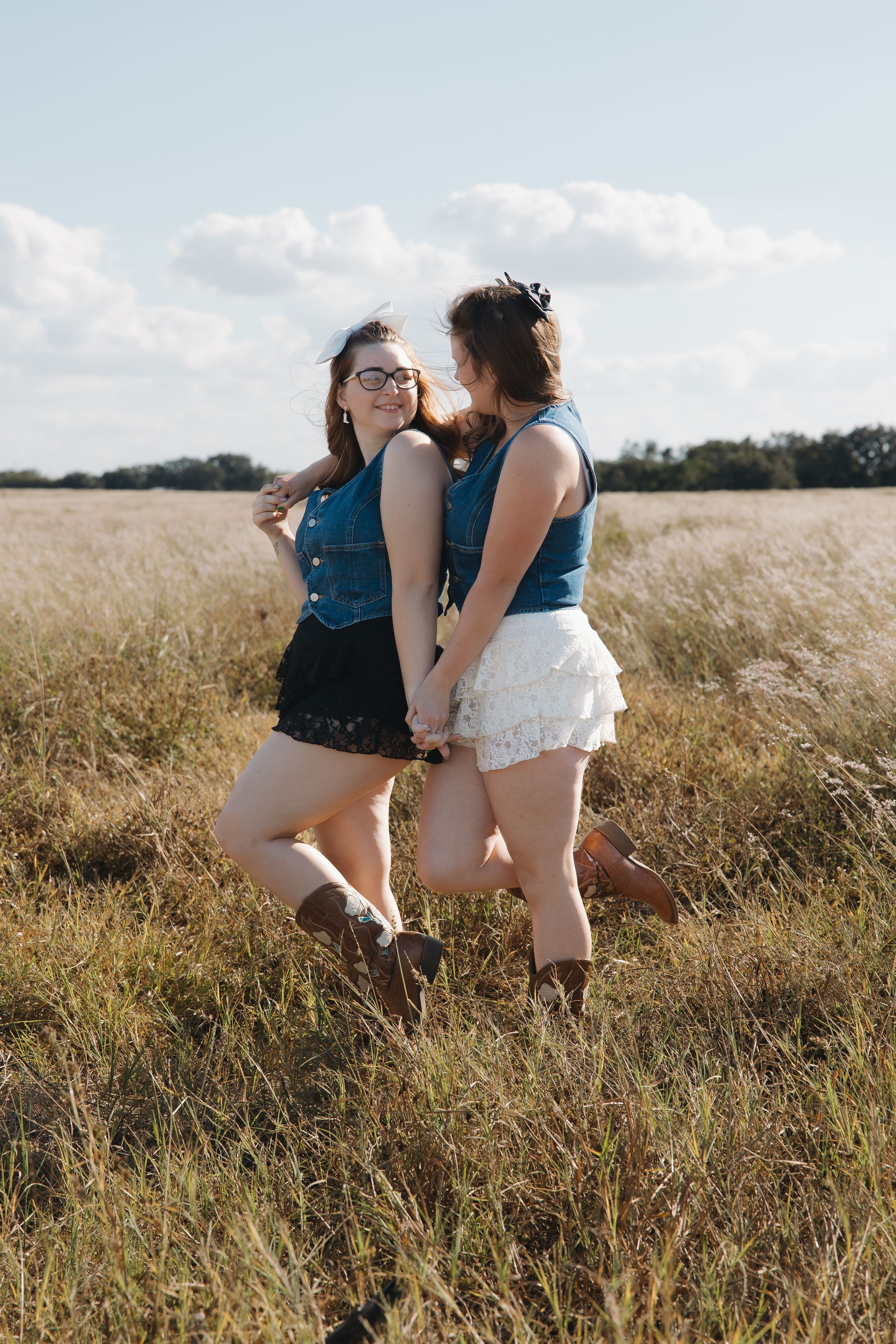 Two friends sharing joyful moment together in golden summer field.