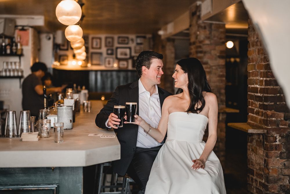 Romantic couple share intimate moment at dimly lit bar counter with vintage lighting.