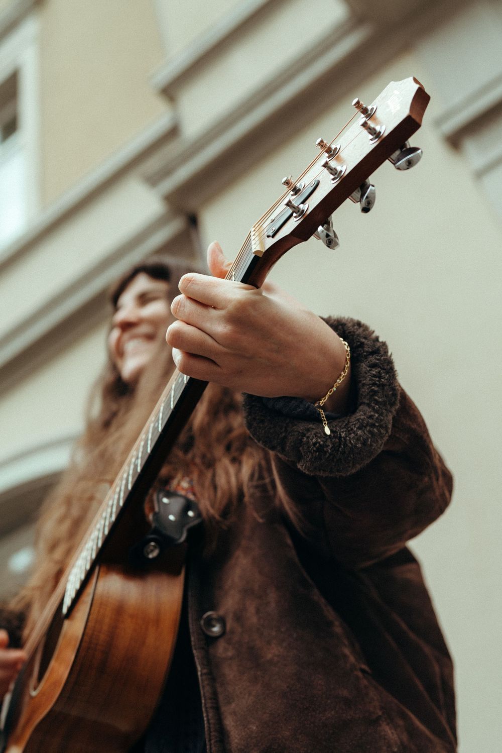 Personal branding an lifestyle photography: Young female musician sitting on a bench in Winterthur playing the guitar. Close up.