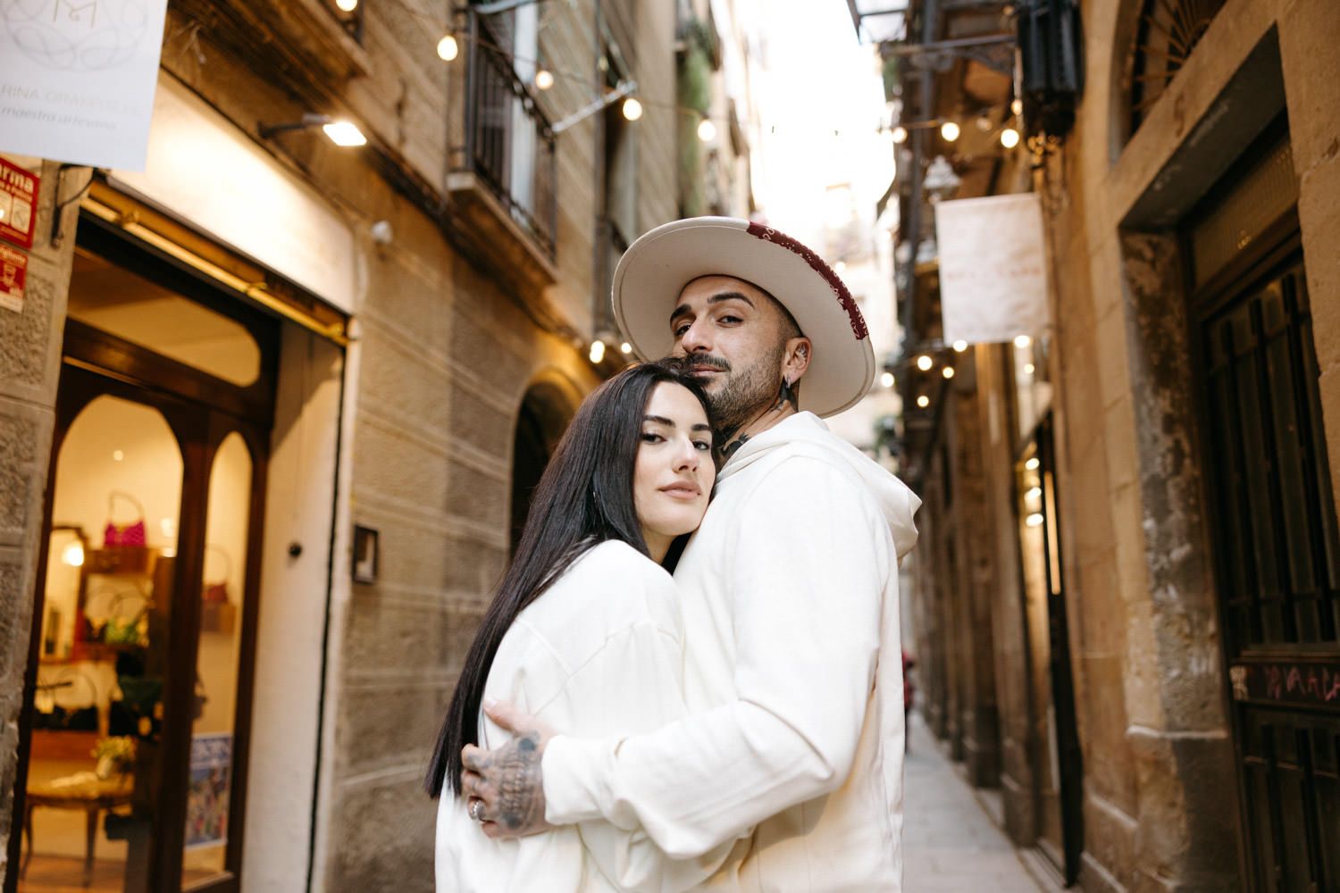 People in white outfits walking through narrow European alleyways with historic architecture.