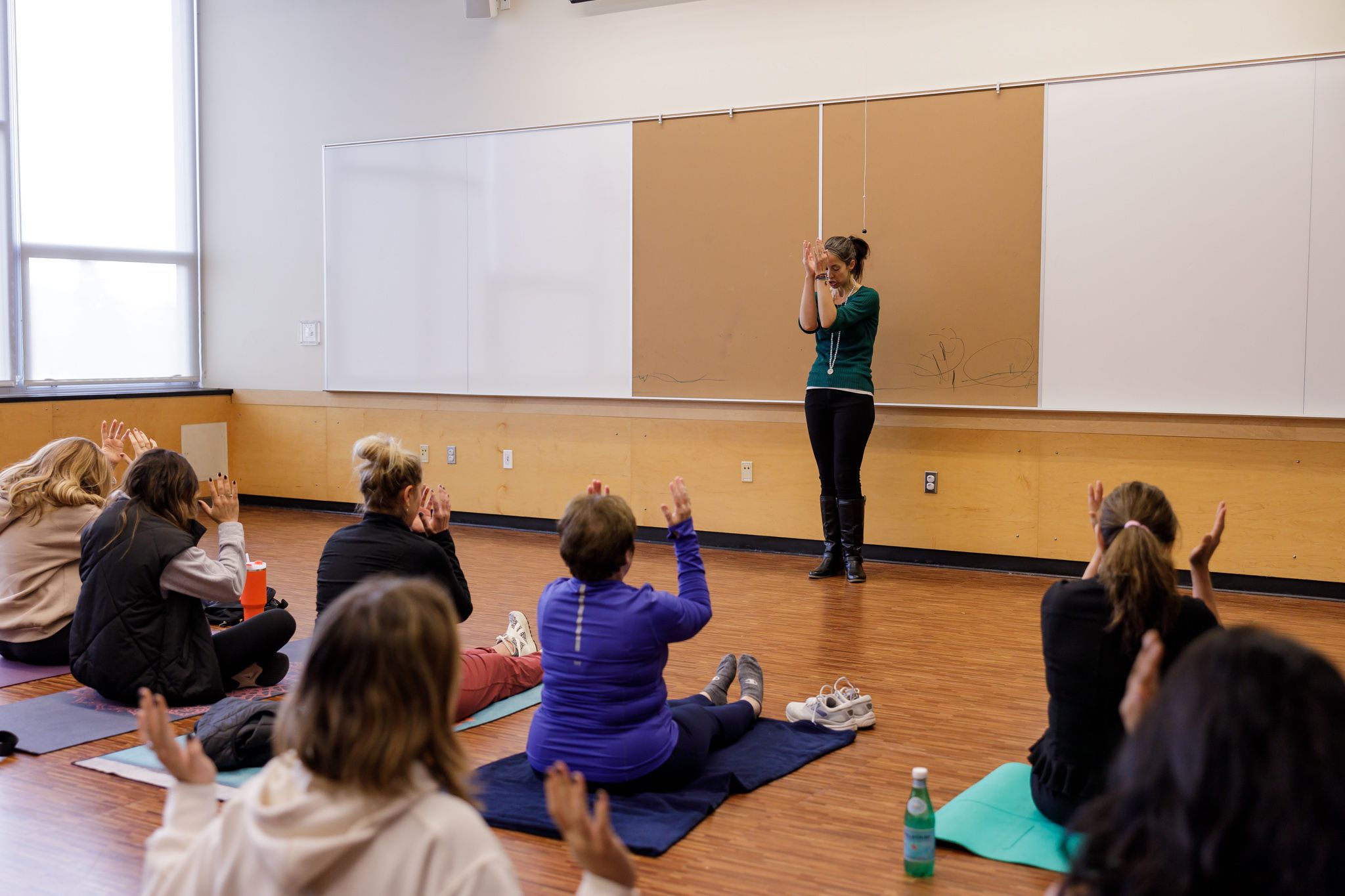 woman leading breathing and movement meditation class for group of women in conference room for Eastside Women's Day of WEllness