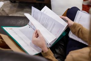 woman productivity business coach for business owners planning workshop woman flipping through workbook while sitting on couch to learn
