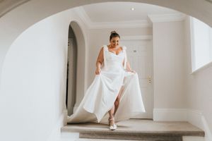 A person wearing a flowing white wedding dress walks through an archway at Healing Manor - image captured by Grimsby photographers.