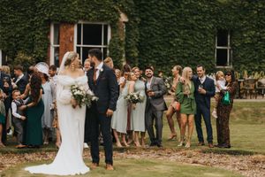 Wedding guests gather on a lush lawn at an outdoor ceremony, captured in a series of candid moments.