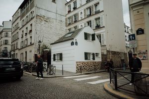 Coin de rue pittoresque à Montmartre avec petite maison, ambiance authentique parisienne.
