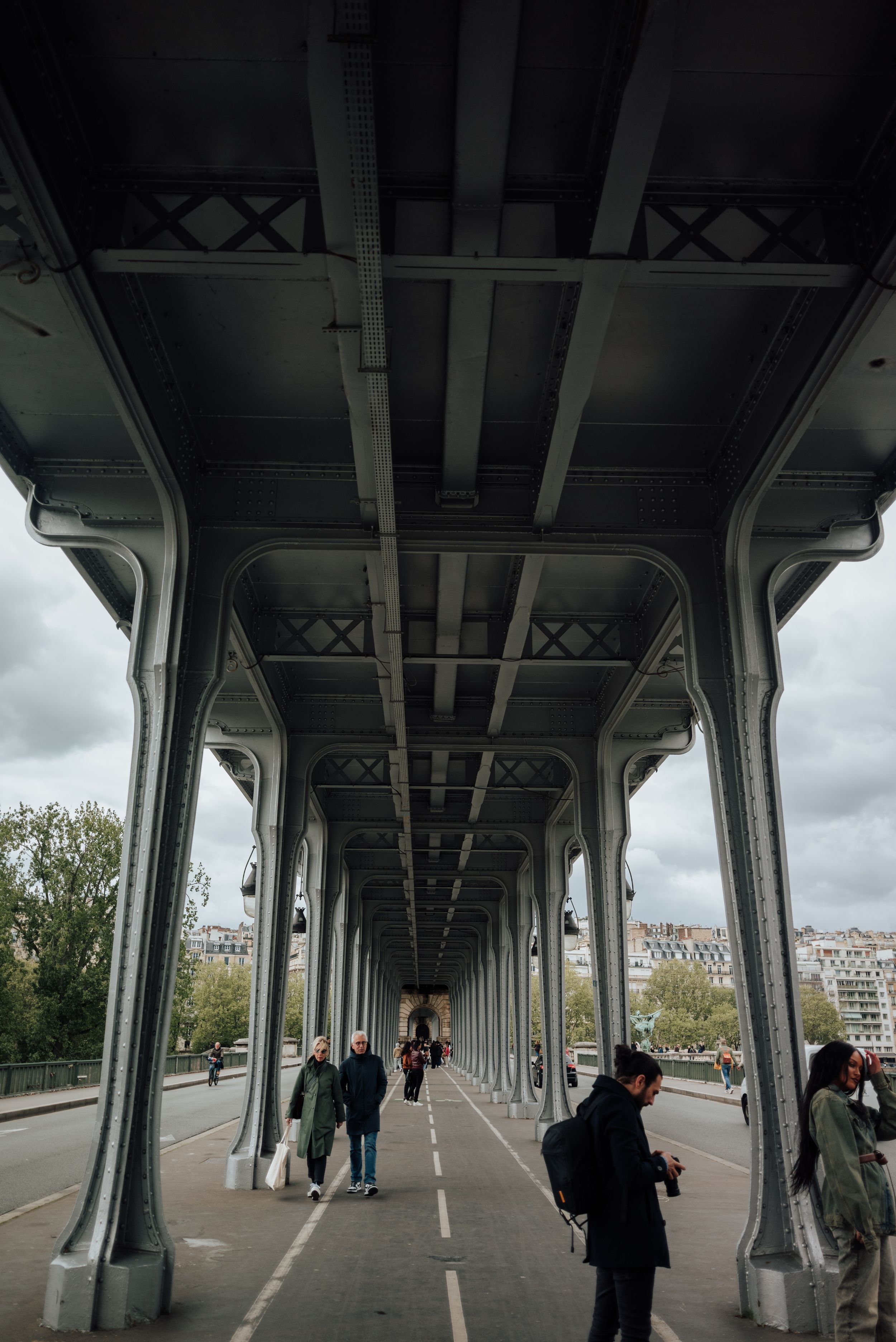 Architecture symétrique du pont Bir-Hakeim à Paris, avec promeneurs et vue sur la ville.