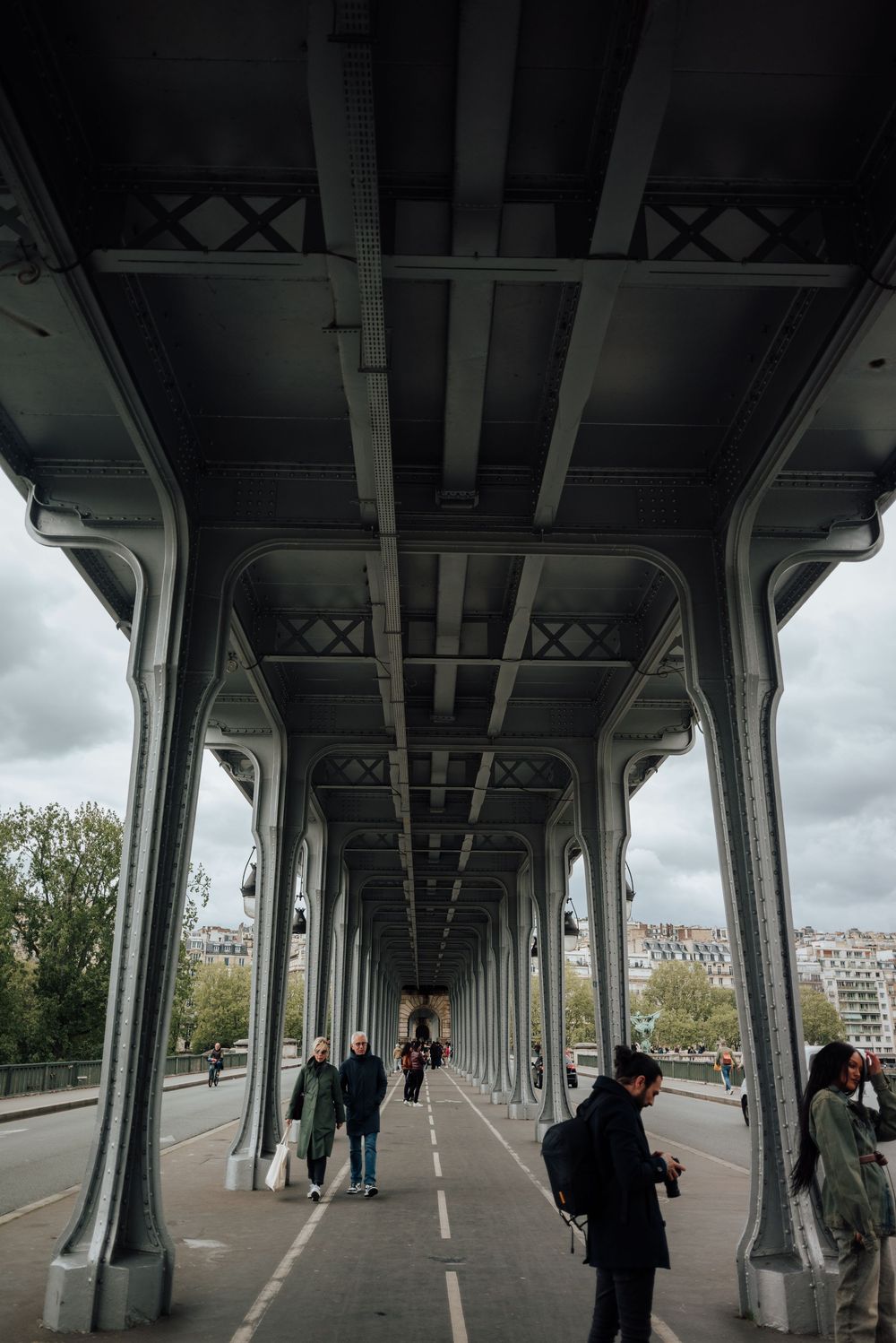 Architecture symétrique du pont Bir-Hakeim à Paris, avec promeneurs et vue sur la ville.
