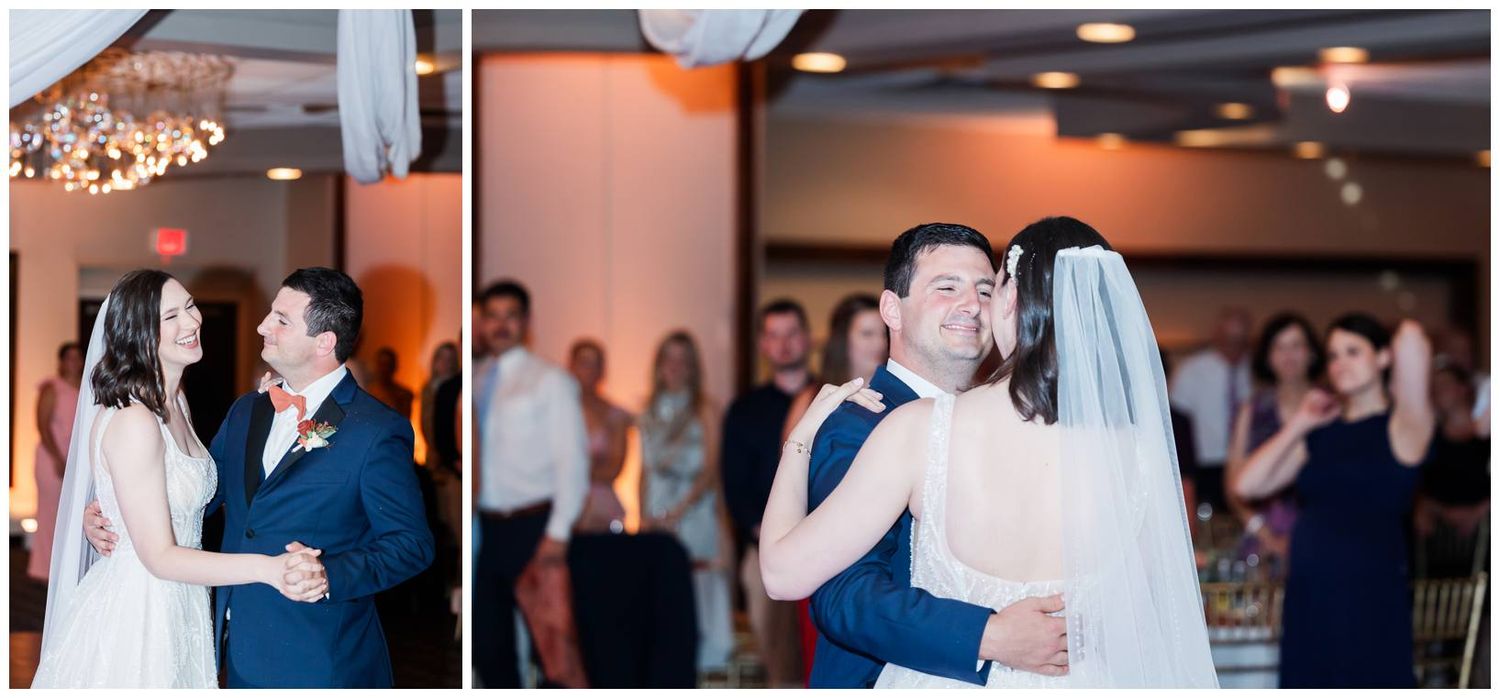 Dancing couple in wedding attire surrounded by guests on a dance floor with warm lighting.