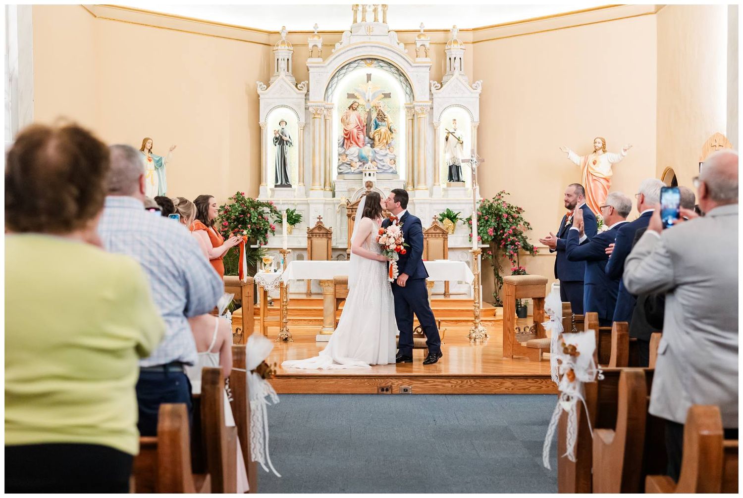 Interior of traditional church with warm lighting and wooden pews during wedding ceremony.