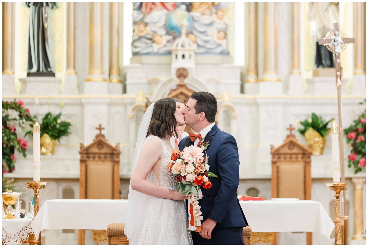 Couple exchanging vows at ornate Catholic church altar during wedding ceremony.