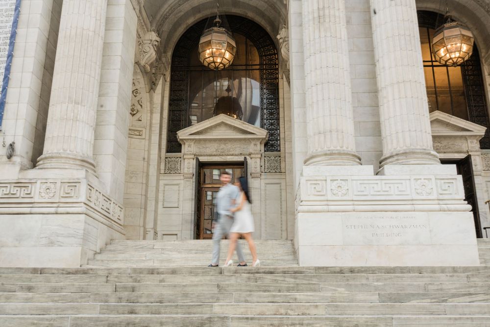Wide architectural shot of grand marble building entrance with classical columns and steps.