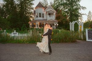 Newlywed couple shares their first dance together in the courtyard of an elegant estate at sunset.