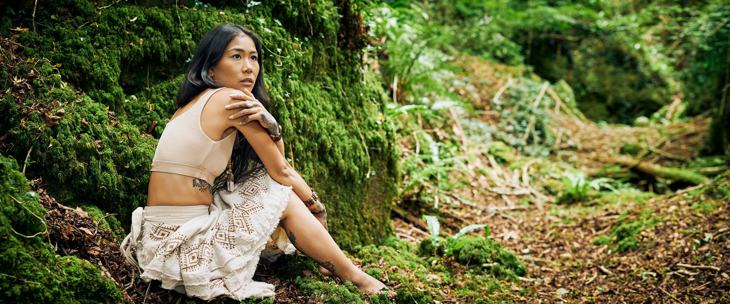 Forest of dean near Gloucester. Outdoor beauty image of a woman in a white dress in the green ferns.