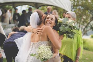 A wedding scene with a friend hugging the bride in congratulations