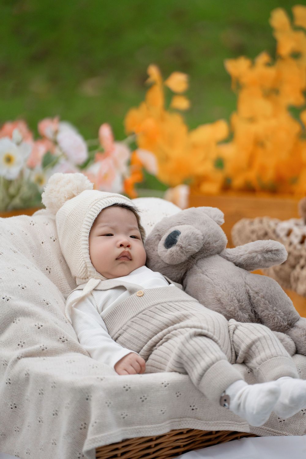Adorable 100 days baby milestone outdoor photography with cute teddy bears, captured by a professional Auckland baby photographer.