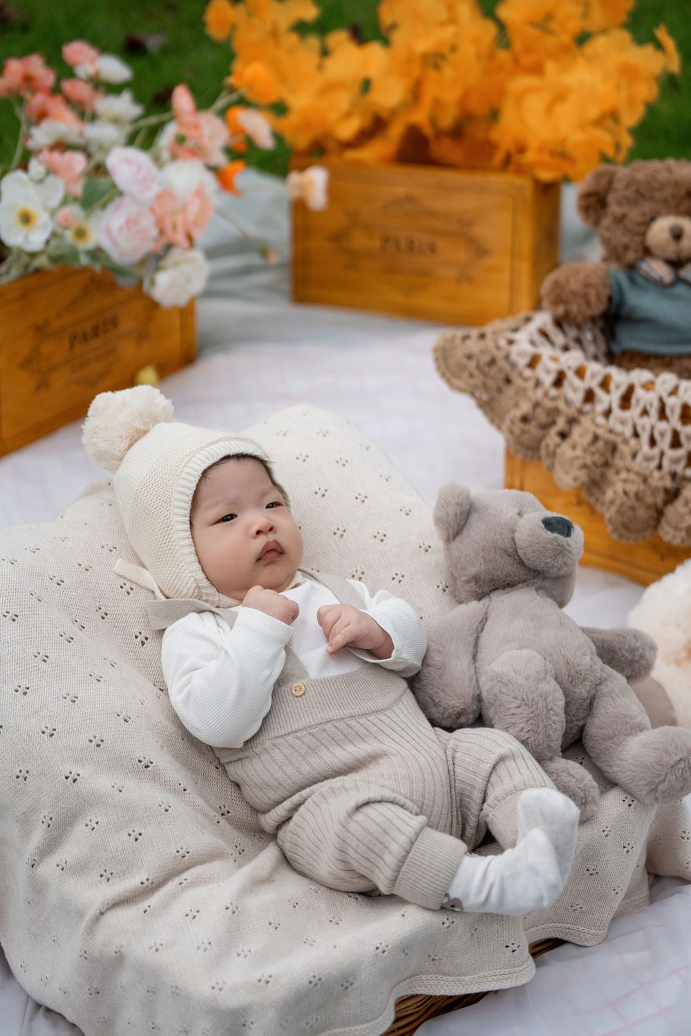 Adorable 100 days baby milestone outdoor photography with cute teddy bears, captured by a professional Auckland baby photographer.
