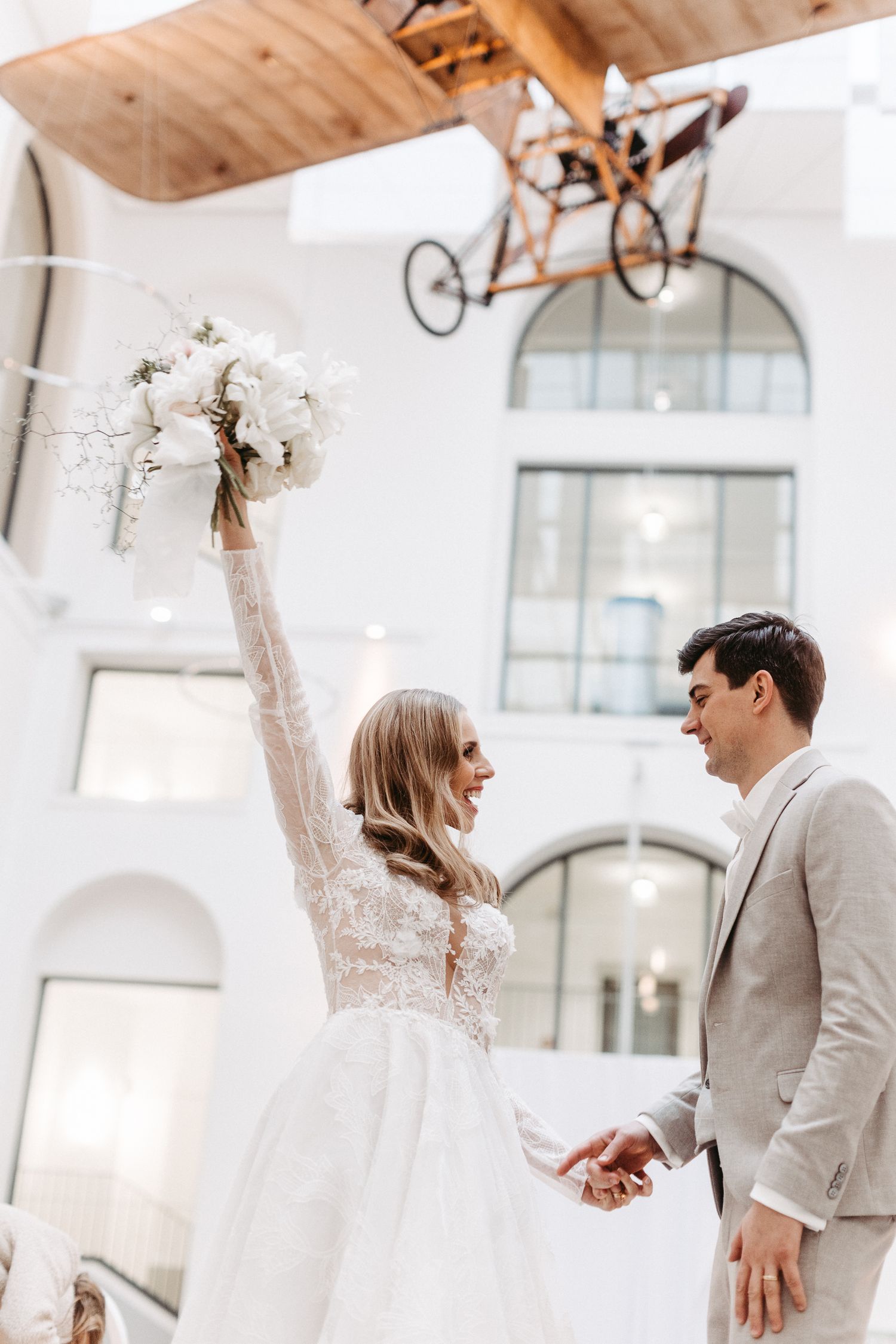 A romantic celebration with white decor and floral arrangements in an elegant indoor venue with white arches.