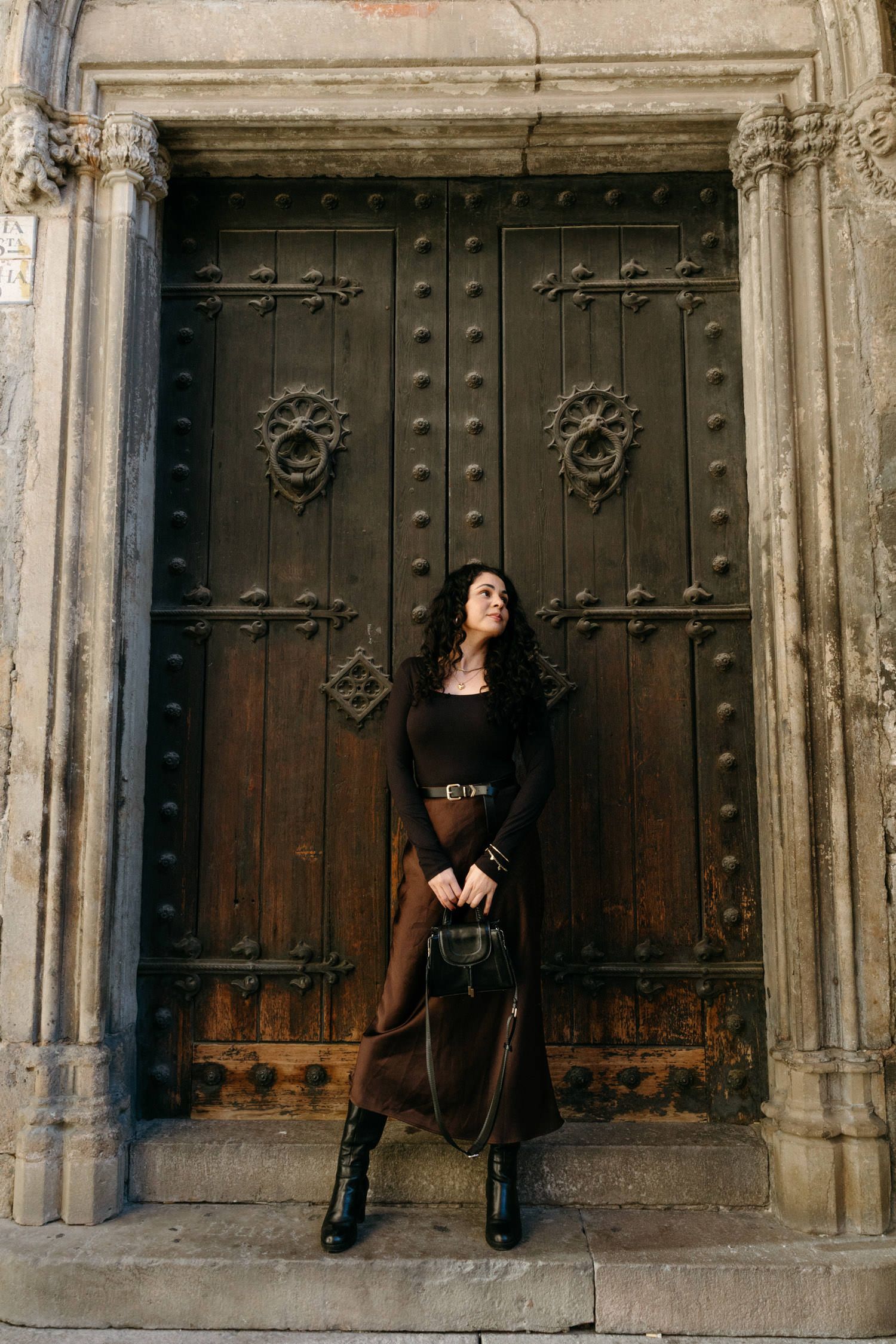 Ancient wooden doors with ornate metal details and stone archway entrance.