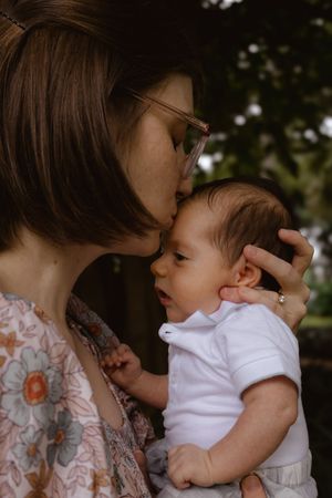 Intimate close-up moments between parent and baby in natural setting.