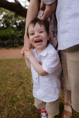 Joyful candid moments between parent and smiling baby outdoors.