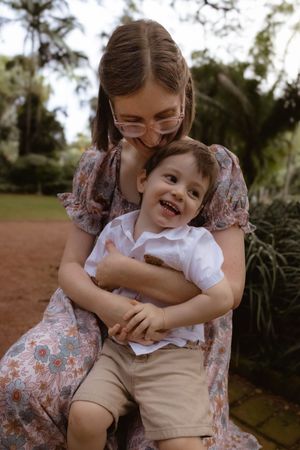 Sweet candid moments of affection and laughter between family members in an outdoor setting.