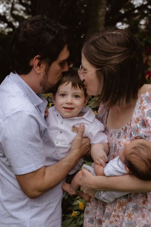 Candid moments of family affection and playfulness captured in an outdoor setting.