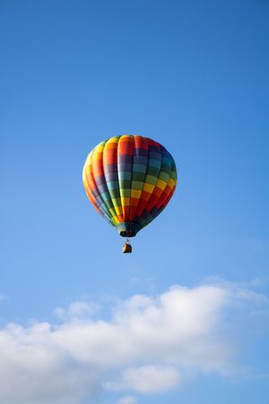 Vibrant hot air balloons soaring through clear blue skies on a sunny day.