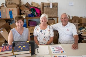 Volunteers working at registration tables with boxes and supplies during balloon festival event.