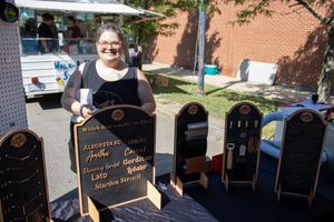 Chalkboard signs and merchandise displays set up at outdoor market vendor booth.