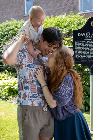Couple sharing a joyful moment together outdoors near a memorial plaque.