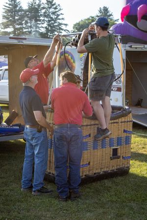 People lined up at outdoor vendor stalls with wicker baskets at a local fair.